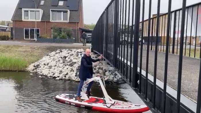 Wethouder Maarten Both luidt de bel vanaf zijn waterfiets.