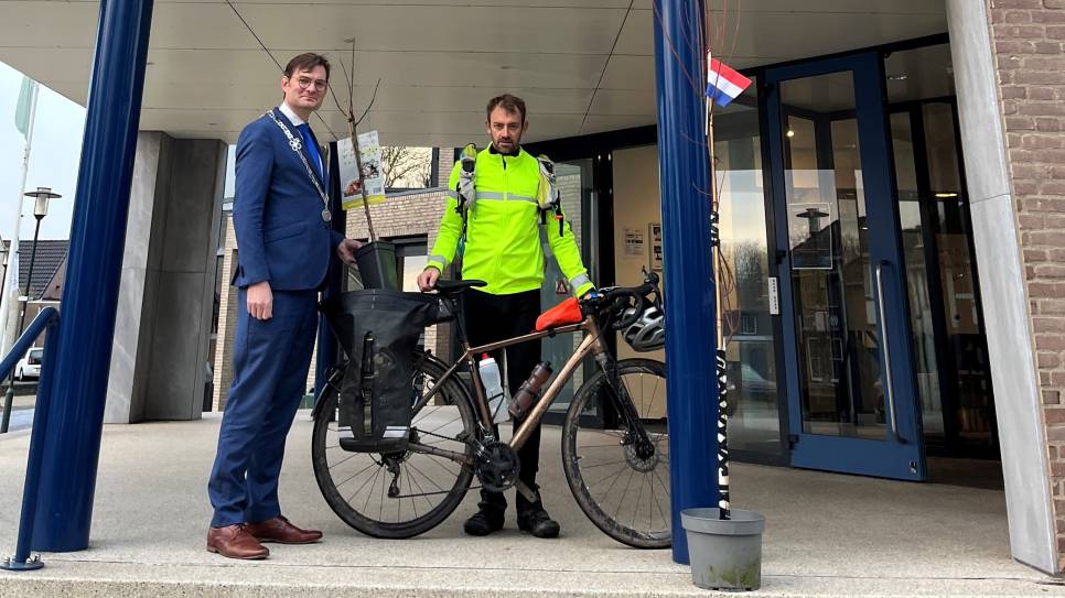 Burgemeester Constantijn Jansen op de Haar en koerier Arnaud Raymond wisselen vriendschapsboompjes uit.