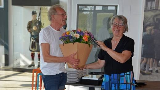 Adri Rottier ontvangt de bloemen, de speld en de oorkonde uit handen van wethouder Marga van de Plasse.