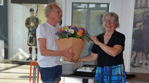 Adri Rottier ontvangt de bloemen, de speld en de oorkonde uit handen van wethouder Marga van de Plasse.