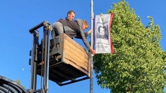 Kapelle eert omgekomen soldaten met foto's op vlaggen