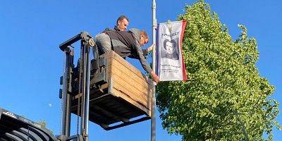 Kapelle eert omgekomen soldaten met foto's op vlaggen