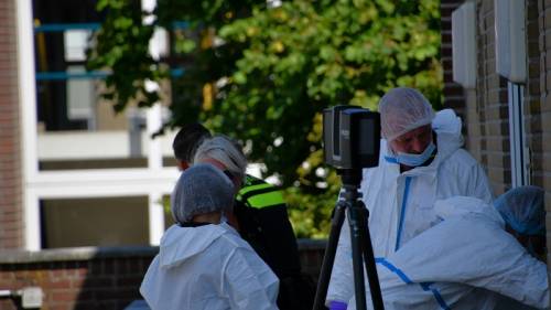 meerdere rechercheurs in witte pakken doen onderzoek