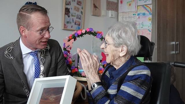 burgemeester Cees van den Bos feliciteert mevrouw Adriana (Jaan) Verhage-Aarnoutse