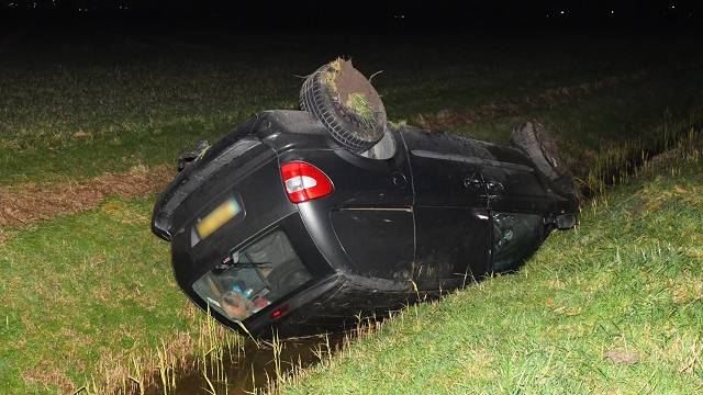 de personenauto raakte door onbekende oorzaak op zijn kop in een sloot