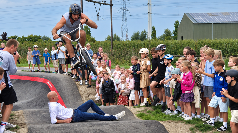 Stunten op de pumptrack: een BMX-manoeuvre met wethouder Maarten Both (liggend)