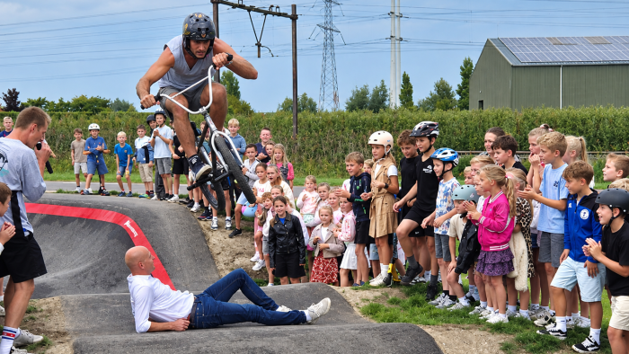 Stunten op de pumptrack: een BMX-manoeuvre met wethouder Maarten Both (liggend)