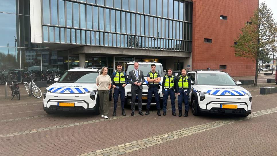 De handhavers met burgemeester Van den Bos (midden) bij de nieuwe wagens.
