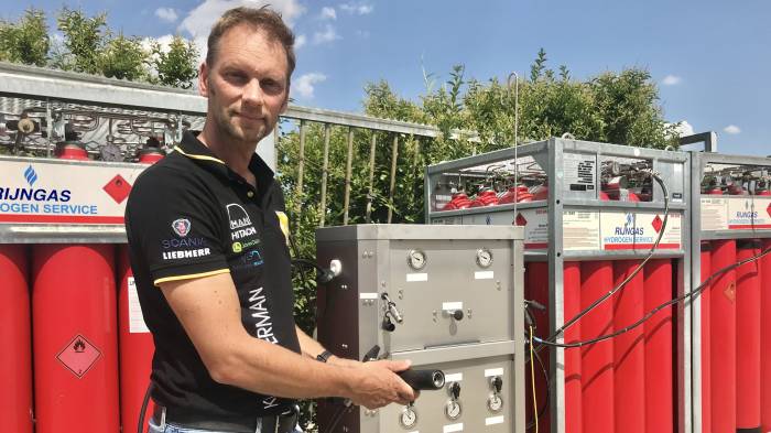 Carlo Kloosterman bij het tankstation, bestaande uit vier units van zestien waterstofcilinders elk. De leverancier wisselt lege cilinders om voor volle.