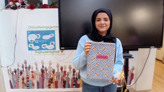 Vrijwilliger Maria krijgt een cadeautje van een van de kinderen uit de groep