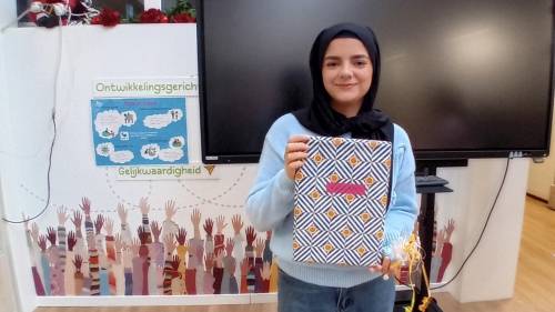 Vrijwilliger Maria krijgt een cadeautje van een van de kinderen uit de groep