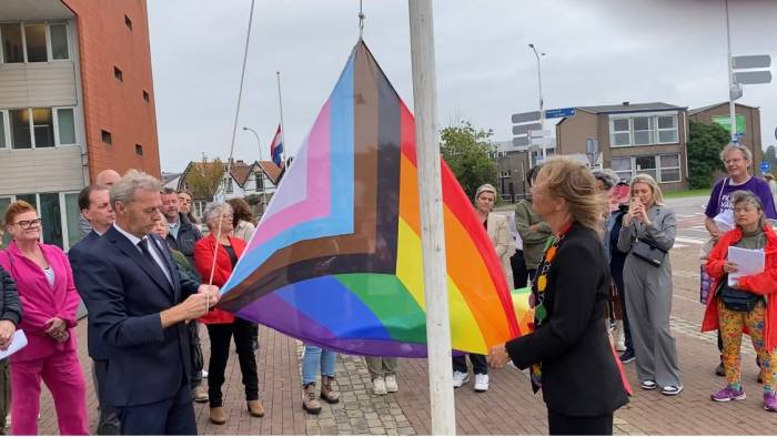 Joan Veldhuizen (rechts) hijst de Progress Pride Vlag in Goes.