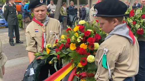 Jongeren dragen een krans.