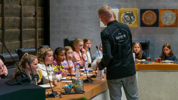 De bakker brengt het brood langs de tafels