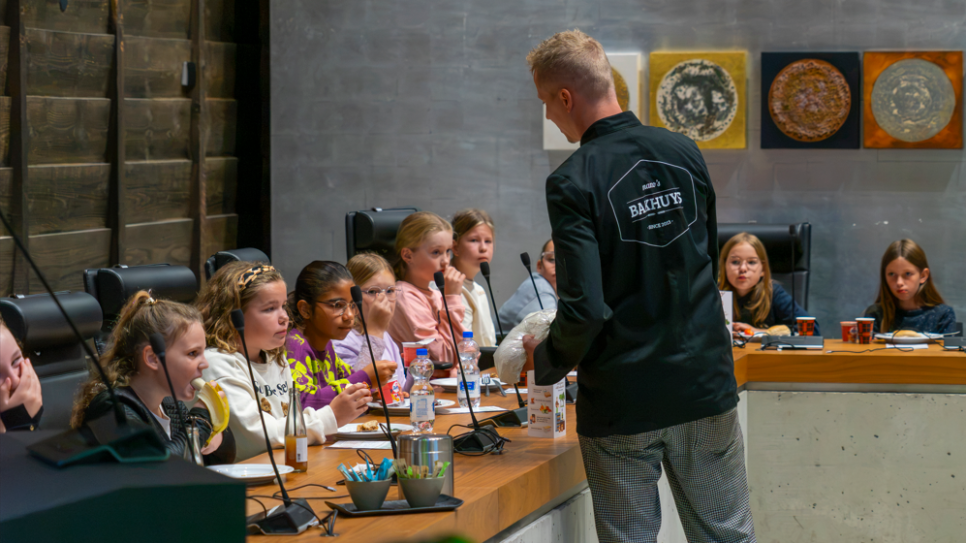 De bakker brengt het brood langs de tafels