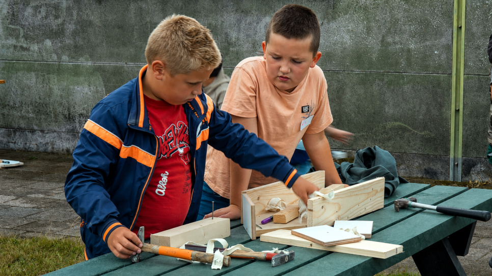 Kinderen maken een bootje, na het verhaal van Noach.