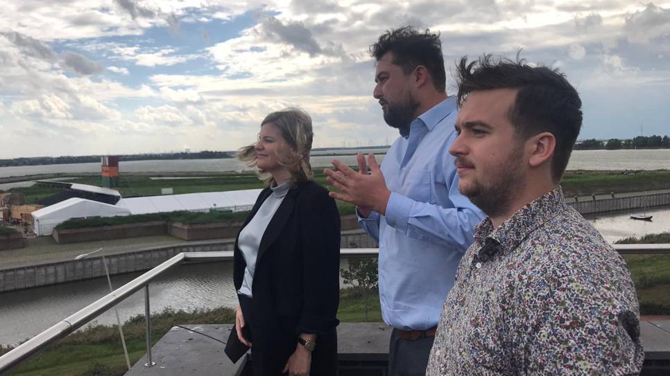Minister Schreinemacher (links) op een uitzichtplatform. Op de achtergrond de haven van Antwerpen en de windmolens bij Rilland.