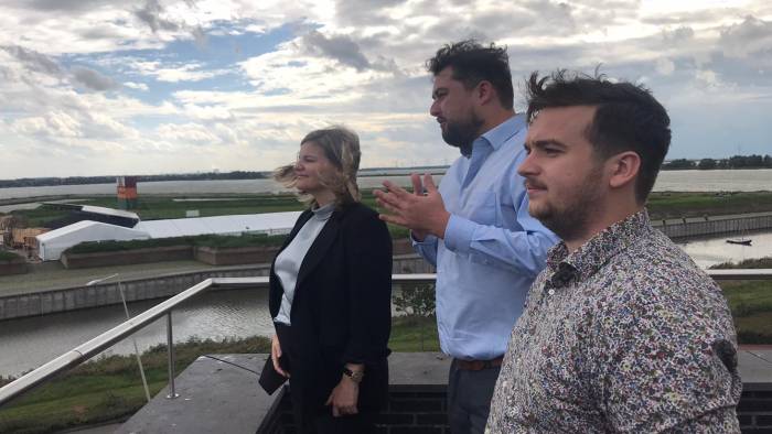 Minister Schreinemacher (links) op een uitzichtplatform. Op de achtergrond de haven van Antwerpen en de windmolens bij Rilland.